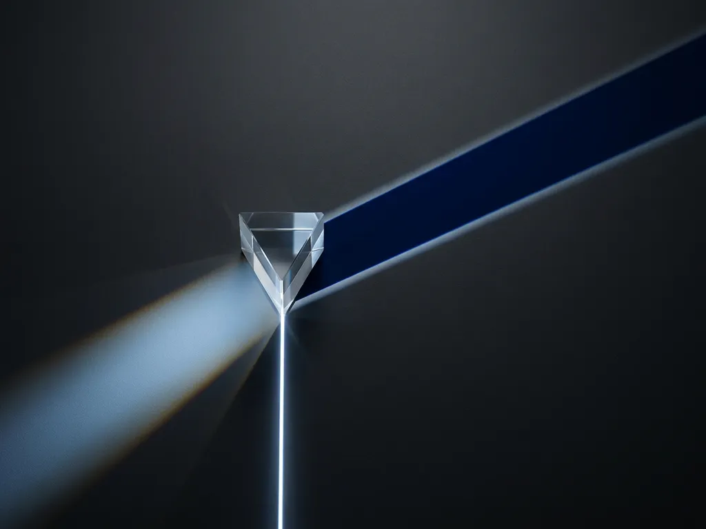 Glass prism splitting a laser beam into two diverging paths on a dark matte surface, midnight blue and arctic white tones with amber accent.
