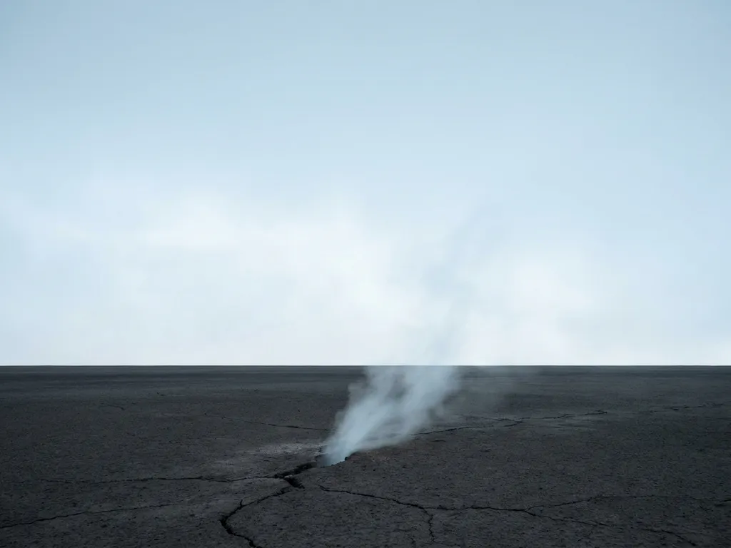 Pale vapor rising from cracked dark earth against a vast arctic blue sky, minimalist composition with geometric horizon line.